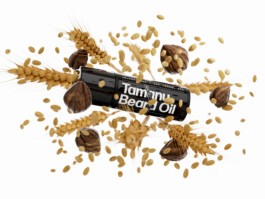 A product shot of Prettyboy Tamanu Beard Oil surrounded by an explosion of its ingredients. 